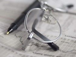 gafas, bolígrafo y periódico