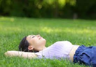 Chica tumbada en una pradera sumida en un profundo sueño