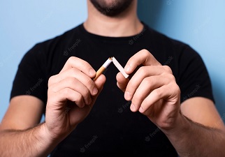 Una persona joven rompiendo un cigarrillo como forma de romper con el tabaco