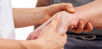 Médico revisando la mano de una persona que sufre tenosinovitis