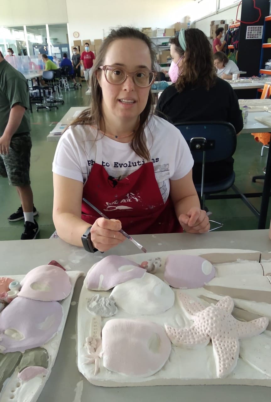 Chica con síndrome de Down pintando una escultura