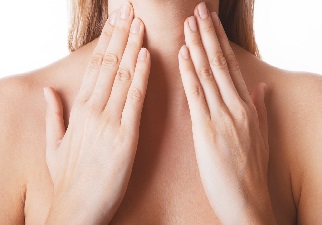 Una persona tocándose las glándulas tiroides