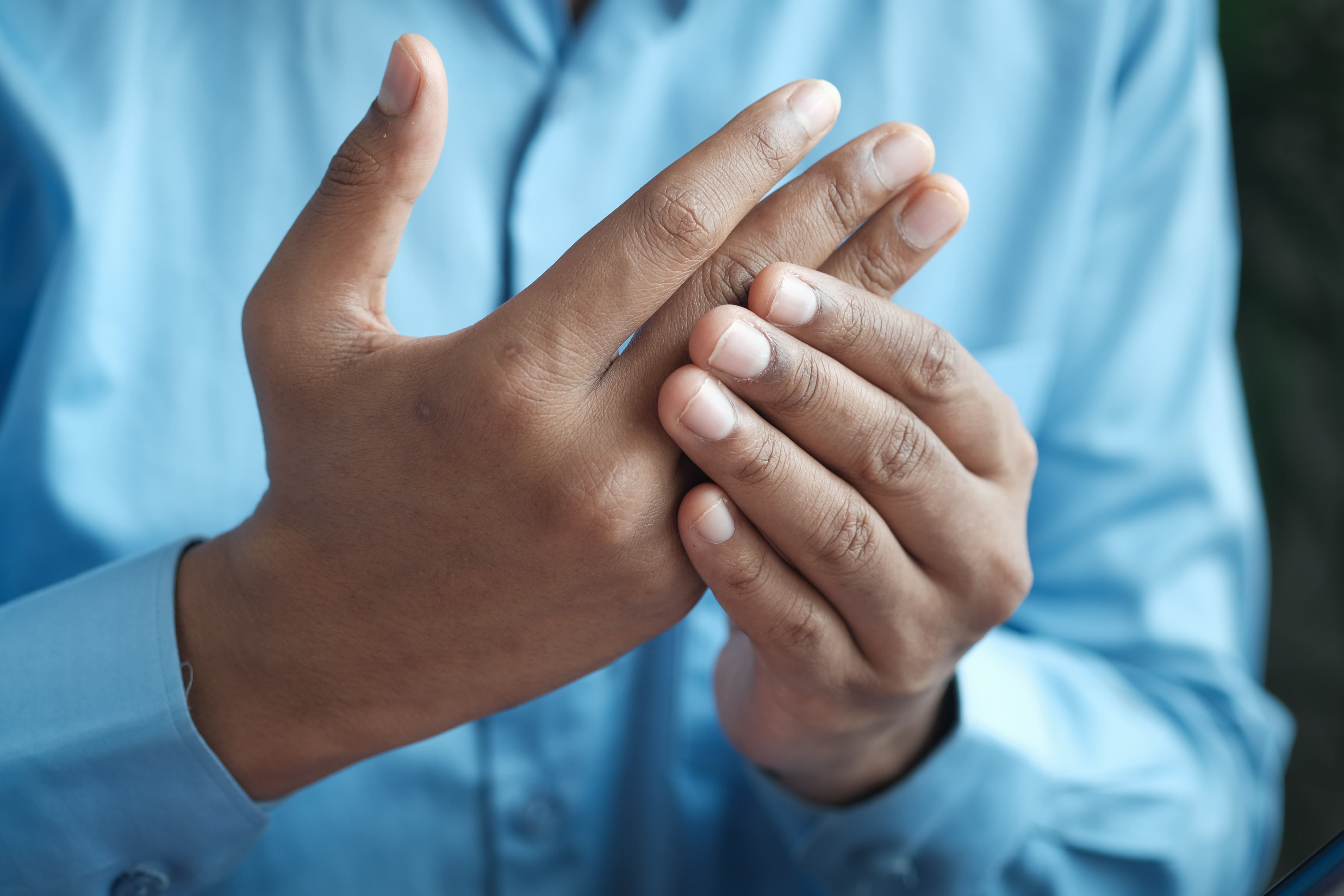 hombre tocándose la mano por dolor de artritis