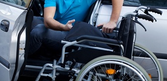 Un joven en silla de ruedas saliendo de su transporte privado