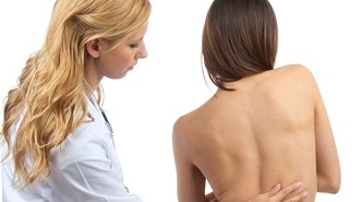 doctora tocando la espalda de paciente en busca de Trastornos muscoesqueléticos