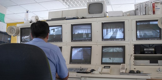 persona delante de varios televisores para investigación audiovisual