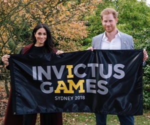 Príncipe Harry y su mujer con la bandera de los juegos