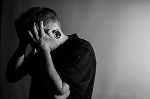 Un hombre se tapa la cabeza con sus manos durante un ataque de ira