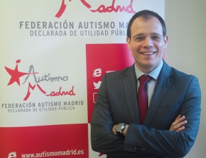 Luis Pradillos delante del cartel de Federación Autismo Madrid
