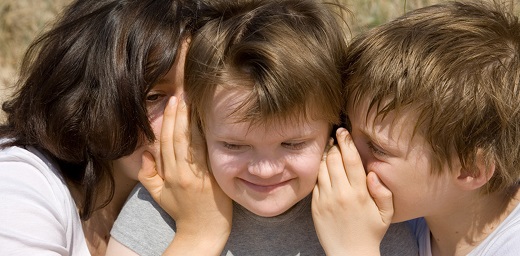 menores con autismo, tres menores, dos hablando al oido del sentado en el medio