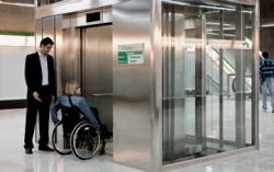 chica en silla de ruedas esperando ascensor en el metro