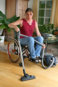 mujer en silla de ruedas pasando aspiradora