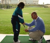 Deportes adaptados: Monitor con niña con discapacidad enseñándole golf