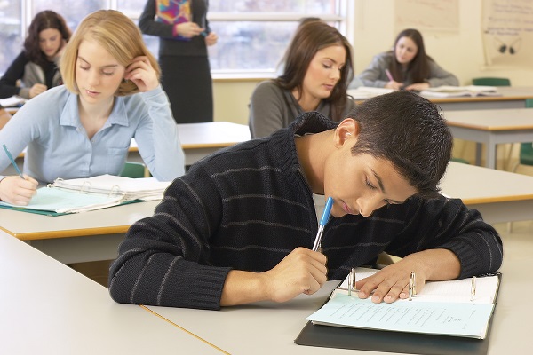 Estudiantes tomando apuntes en clase