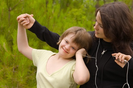Una mamá escucha con su hijo música con los mismos auriculares y mostrando humor y felicidad