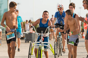 Grupo de jóvenes aimando a un participante en la carrera de bicicleta