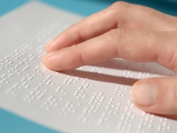 mano leyendo documento en lenguaje braille