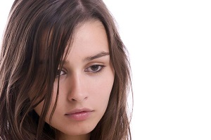 Una joven que su cara muestra ansiedad y tristeza