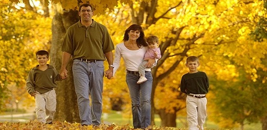 Tratamiento fiscal de la discapacidad, una familia con sus tres hijos paseando por un campo