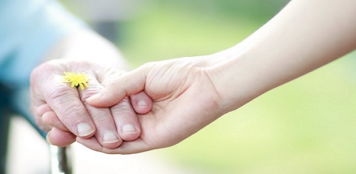 Dos manos juntas, una de una persona joven y otra de edad más avanzada, en señal de soledad