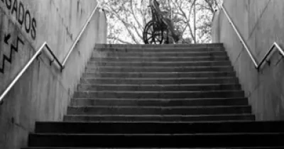 Mujer en silla ruedas que no puede bajar a los juzgados debido a las escaleras