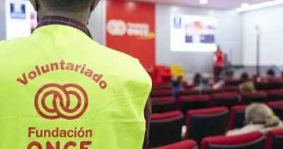 Voluntario de la ONCE de espaldas, mirando hacía el evento de Fundación Once