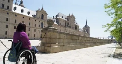Mujer en silla de ruedas admirando el Escorial