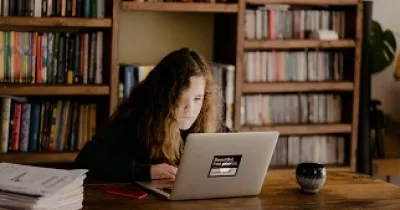 niña en biblioteca estudiando
