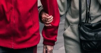dos personas mayores cogidas del brazo paseando