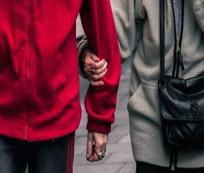 dos personas mayores cogidas del brazo paseando