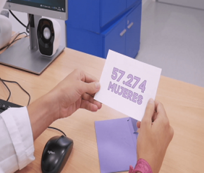 manos cogiendo una tarjeta morada que pone, 57.274 mujeres