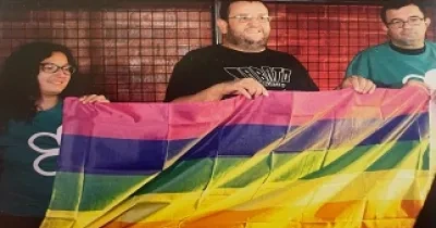 tres personas sujetando la bandera LGTBI