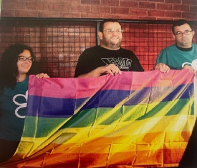tres personas sujetando la bandera LGTBI