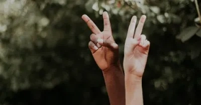 dos manos mostrando dos dedos en forma de V, por los derechos humanos