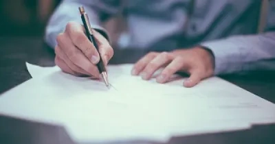 hombre firmando un papel