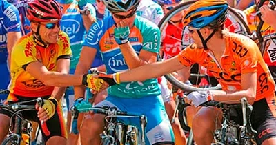 Grupo de Ciclistas antes del comienzo de una carrera estrechándose la mano para desearse suerte