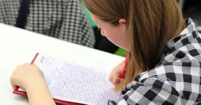 Chica estudiando con apuntes sobre la mesa