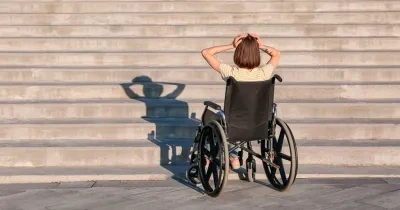 Persona con discapacidad ante una escalera