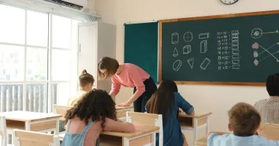 Una profesora atiende a sus alumnos en clase
