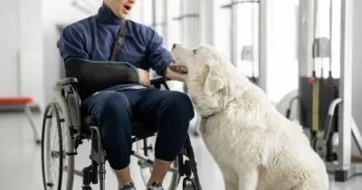 Un joven con discapacidad acaricia a su perro 