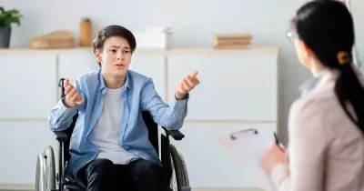 persona en silla de rueda hablando con un doctor