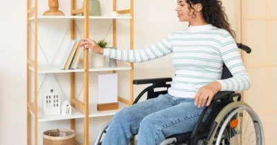 Una mujer coge un libro de una estanteria de su hogar