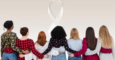 Varias mujeres están de espaldas y con sus brazos entrelazados