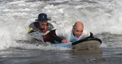 Niccolò Taverna en una sesión de surf terapeútico con un alumno