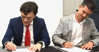 los directores de ambas entidades rubricando el acuerdo