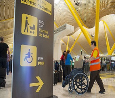 Un operario del Servicio de Asistencia a Personas con Discapacidad o Movilidad Reducida, 'Sin Barreras', de Aena, llevando una silla de ruedas (Fuente: Aena)