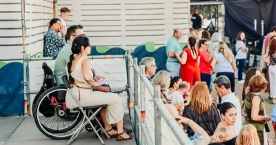 Una mujer en silla de ruedas en un lugar accesible de un evento