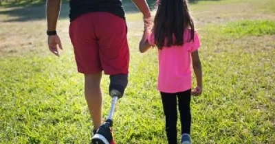 Un padre con discapacidad física pasea con su hija por el parque (Fuente: Servimedia)