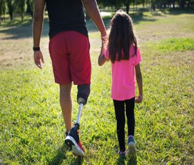 Un padre con discapacidad física pasea con su hija por el parque (Fuente: Servimedia)