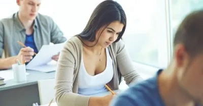 Una mujer junto a sus compañeros realizando una de las pruebas selectivas para empleo público (Fuente: Servimedia)